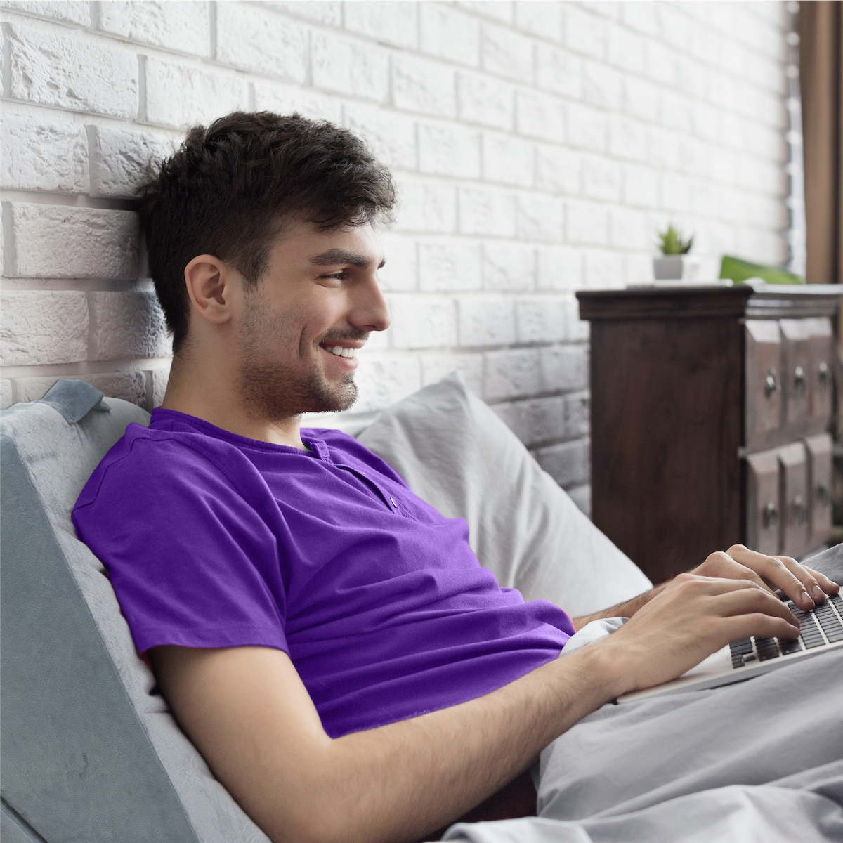 folding wedge pillow used by man in purple shirt