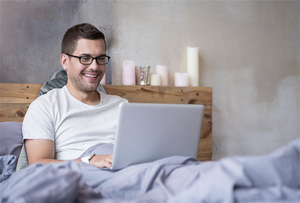reading pillow used by a man while using laptop